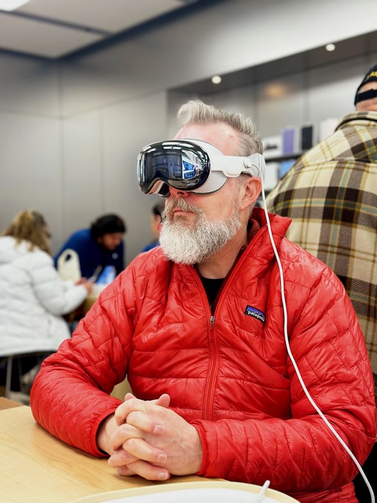 Me sitting at a table wearing an Apple Vision Pro headset during the demo