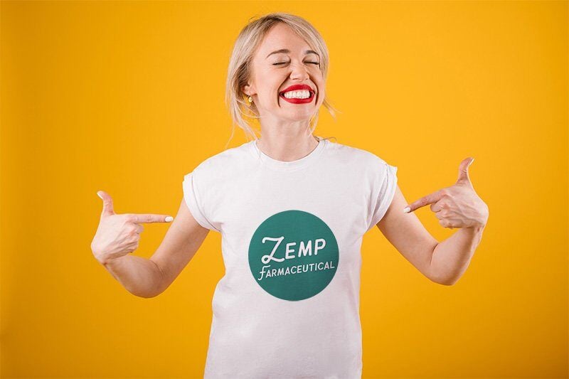 A smiling young woman wearing a Zemp Hemp t-shirt while standing in front of a yellow wall